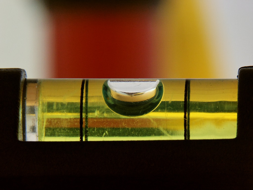 Close-up of the bubble vial of a spirit level, the bubble centred between two lines.